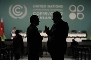 Delegates talk during a break in a plenary session on the second day of the 19th conference of the United Nations